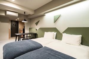 2 camas en una habitación con mesa en Section L Kuramae - Asakusa en Tokio