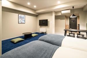a hotel room with two beds and a table at Section L Kuramae - Asakusa in Tokyo