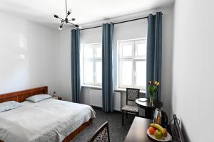 Un dormitorio con una cama y una mesa con un bol de fruta en A&J Studios Mostowa Old Town, en Poznan