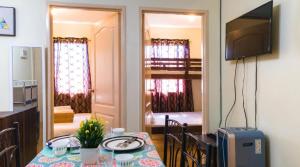 a dining room with a table and a television in a room at Kara's Condotels in Cebu City