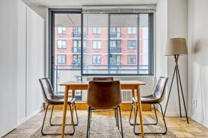 a dining room with a table and chairs and a large window at Murray Hill 1BR w Doorman Gym Pool Parking NYC-581 in New York