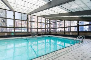 ein großer Pool in einem Gebäude mit Fenstern in der Unterkunft Murray Hill 1BR w Doorman Gym Pool Parking NYC-581 in New York