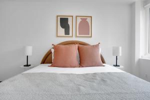 a bedroom with a bed with pink pillows and two lamps at Back Bay 1BR w Gym nr Copley Sq BOS-742 in Boston