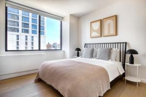 ein Schlafzimmer mit einem Bett und einem großen Fenster in der Unterkunft Upper West Side 2br w gym nr Central Park NYC-1147 in New York + 24 Fotos