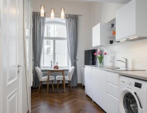 eine Küche mit einem Tisch und Stühlen sowie einem Fenster in der Unterkunft Grand Hotell Residents loft Tartu vanalinnas in Tartu