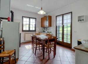 a kitchen with a table and chairs and a refrigerator at Casetta nel verde in Varazze