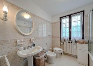 a bathroom with a sink and a toilet and a mirror at Casetta nel verde in Varazze +26 photos