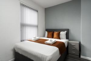 a bedroom with a large bed with two towels on it at Vichy - Strathcona Suites, Houses in Wavertree in Liverpool