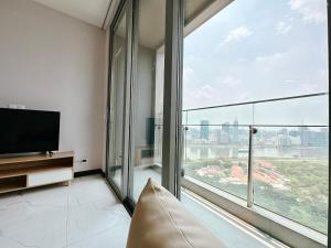 ein Wohnzimmer mit einem TV und einem großen Fenster in der Unterkunft Empire city Thủ Thiêm Luxuriest Apartment Ho Chi Minh city Dist 2 in Ho-Chi-Minh-Stadt