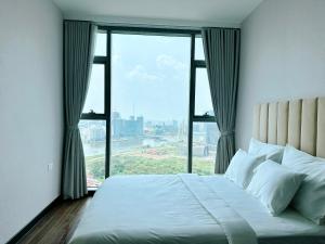 Bett in einem Zimmer mit einem großen Fenster in der Unterkunft Empire city Thủ Thiêm Luxuriest Apartment Ho Chi Minh city Dist 2 in Ho-Chi-Minh-Stadt