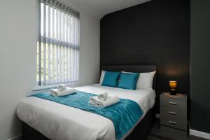 a bedroom with a large bed with towels on it at Vichy - Strathcona Suites, Houses in Wavertree in Liverpool