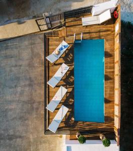 widok na basen z krzesłami i stołem w obiekcie * * *Ammira Mare* *Maisonette near sea with pool w mieście Agia Pelagia