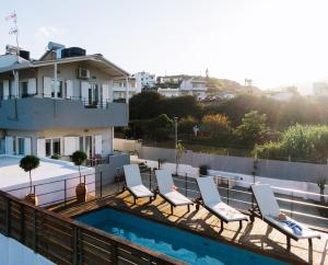 - un ensemble de chaises assises sur un balcon avec piscine dans l'établissement * * *Ammira Mare* *Maisonette near sea with pool, à Agia Pelagia