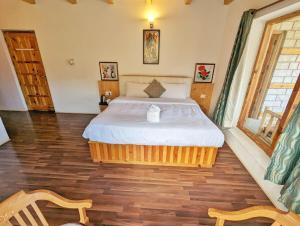 a bedroom with a large bed in a room at Harippur Cottages and Resort - Manali in Manāli