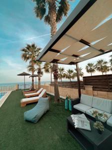 a patio with a couch and chairs under an umbrella at Oasi Rejuve Villa in Meneou