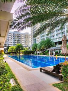 einem großen Pool mit Palmen und einem Gebäude in der Unterkunft Verdon Parc Condominium in Davao City