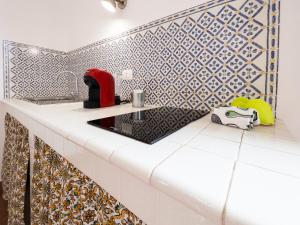 kuchnia z białym blatem i niebiesko-białymi płytkami w obiekcie Elimi Favignana Apartments - Residence in città w mieście Favignana