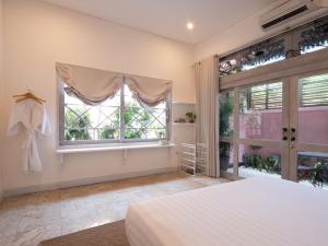a bedroom with a bed and a large window at Kresna By The Sea By Kresna Hospitality in Seminyak