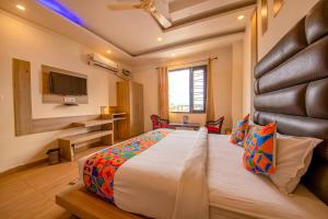 a bedroom with a large bed and a television at FabHotel AS Residency in Dehradun