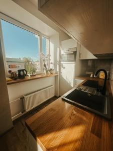 uma cozinha com um balcão e uma janela em Middle street apartment em Alūksne