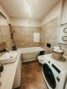 a bathroom with a toilet sink and a washing machine at Middle street apartment in Alūksne