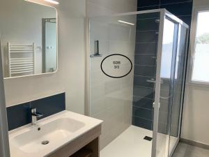 ein Badezimmer mit Waschbecken und Glasdusche in der Unterkunft Ti-roue in Saint-Gildas-de-Rhuys + 22 Fotos