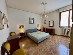 a bedroom with a bed and chairs and a window at Careggi Gold Colors in Florence