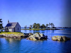 eine Insel mit einer Kirche mitten im Wasser in der Unterkunft Ti-roue in Saint-Gildas-de-Rhuys