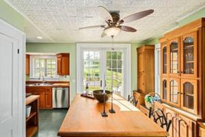 a kitchen with a table and a ceiling fan at Tophet Road, 3-BR with Spa Plunge Pool - PoshPadsCT in Roxbury