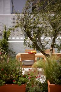 una mesa y sillas en un jardín con plantas en Orloff Legacy Suites Hydra, en Hydra