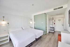 a white bedroom with a large bed and a desk at Hotel Astoria Playa Adults Only 4* Sup in Port d'Alcudia