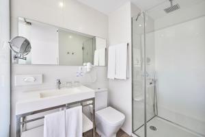 a white bathroom with a sink and a shower at Hotel Astoria Playa Adults Only 4* Sup in Port d'Alcudia