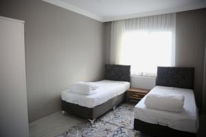 um quarto com 2 camas e uma janela em Araklı Residence em Araklı