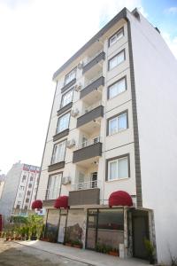 a tall white building with red umbrellas at Araklı Residence in Araklı