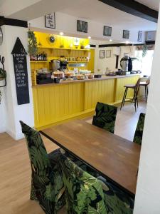 a yellow kitchen with a table and chairs and a counter at OYO The Billingford Horseshoes in Scole