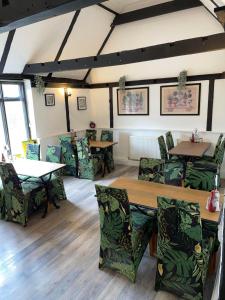 a restaurant with tables and chairs in a room at OYO The Billingford Horseshoes in Scole