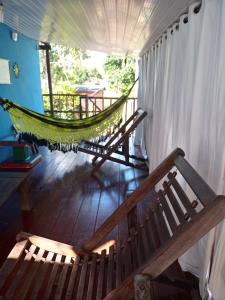 a hammock hanging in a room with a porch at Suítes Novo Amanhecer in Sao Jorge