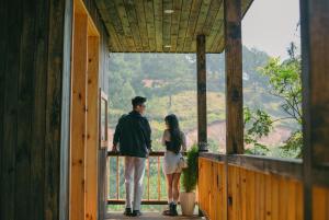 a man and woman standing on the porch of a house at Lavender Dalat Hotel and Resorts in Da Lat