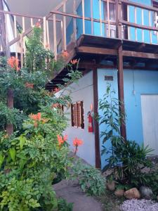 a blue building with a staircase and flowers at Suítes Novo Amanhecer in Sao Jorge