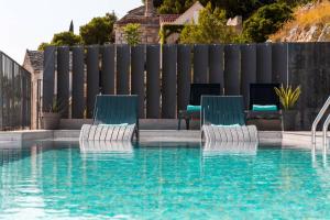 una piscina con 2 sillas azules junto a una valla en Villa Moon en Bol