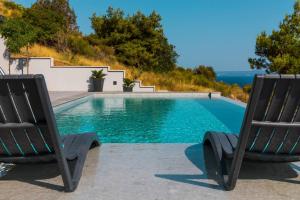 2 sillas sentadas junto a una piscina en Villa Moon en Bol
