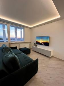 a living room with a couch and a flat screen tv at T3 apartment Self Check-in in Klaipėda