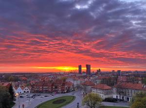 a view of a city with a sunset in the background at T3 apartment Self Check-in in Klaipėda