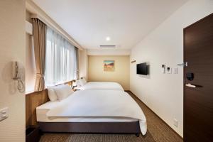 um quarto de hotel com duas camas e uma janela em 若 京都河原町ホテル Waka Kyoto Kawaramachi Hotel em Quioto