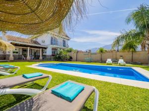 un patio trasero con piscina y una casa en Cubo's Villa La Quinta, en Alhaurín el Grande