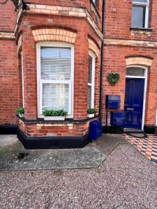 a brick building with a window and two blue chairs at Time Out in Exmouth