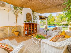 sala de estar al aire libre con sillas de mimbre y mesa en Cubo's Villa La Quinta, en Alhaurín el Grande