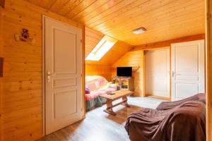 a room with a bed and a fireplace in a log cabin at Gite Du Dombief in La Chaux-du-Dombief