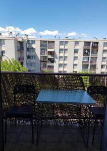 een blauwe tafel en stoelen op een balkon met een gebouw bij Appart 6 pers Marignane à 5 min -plage et aéroport in Marignane