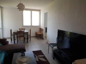 een woonkamer met een televisie en een eetkamer bij Appart 6 pers Marignane à 5 min -plage et aéroport in Marignane